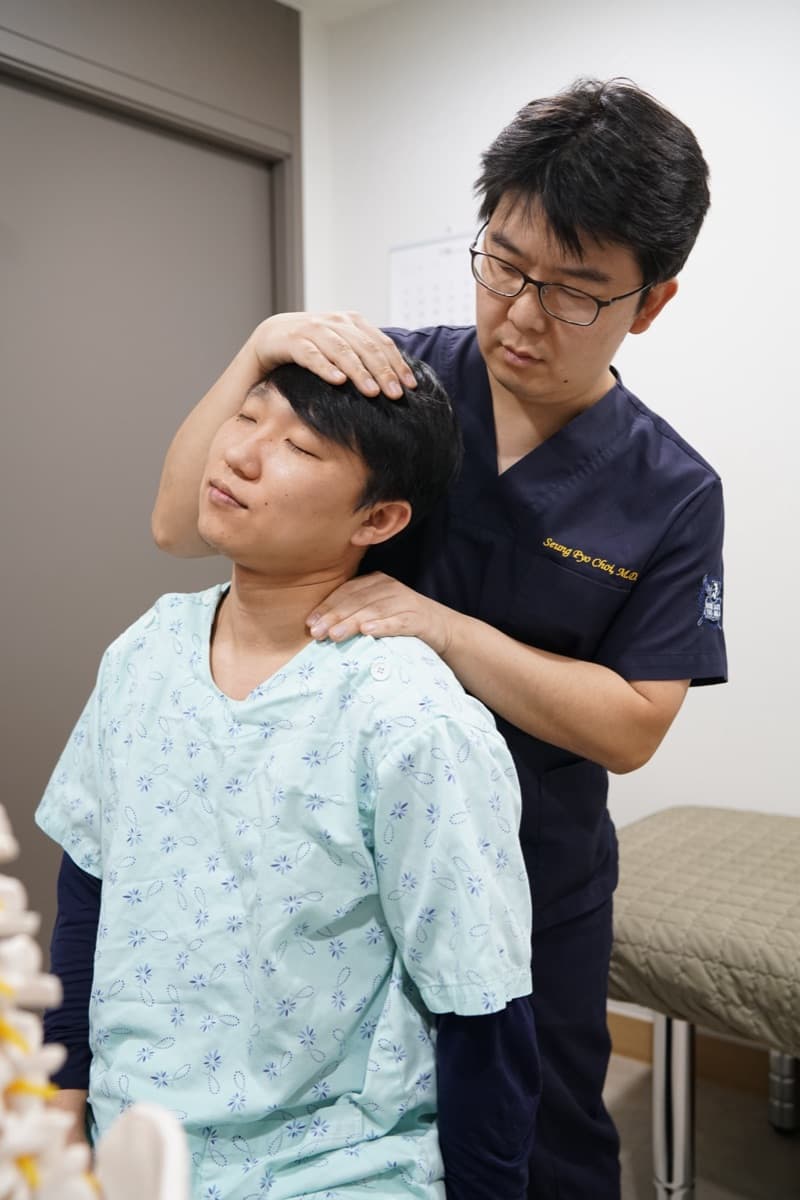 진료실에서 환자의 목 상태를 확인하는 이학적 검사 모습